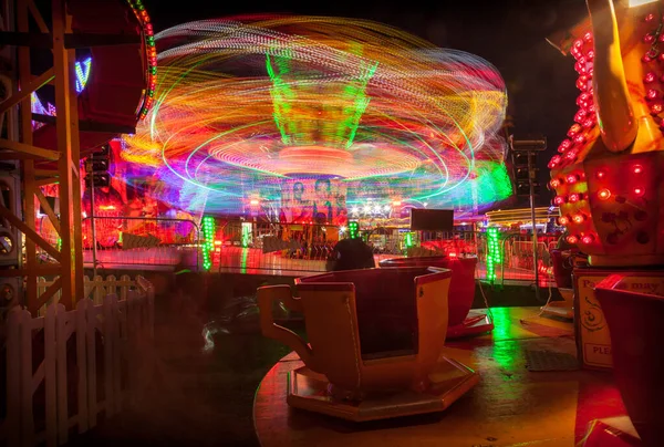 ライトアップされた子供たちの回転するティーカップとウィニー フェスティバル ファンフェアでの 極端な 乗り物 — ストック写真