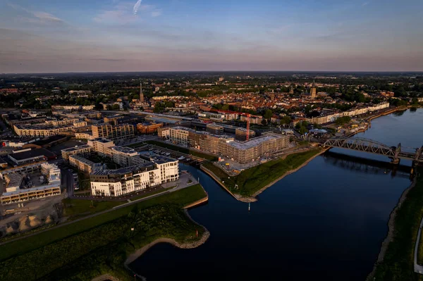 Luxury apartment complex construction at the riverbank of river IJssel between train tracks and recreational port