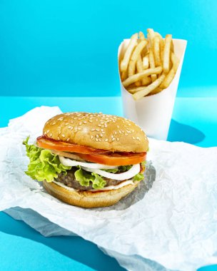 Mavi Arkaplanda Burger ve Kızartma 'nın yakın plan fotoğrafı. Logo için fotokopi alanı var.