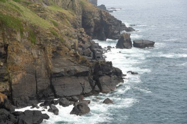 İngiltere 'nin en güney noktası olan Cornwall, İngiltere' deki Lizard Point 'teki kayalık deniz manzarasına bakıyorum..