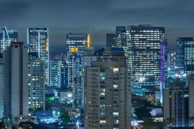 Brezilya 'da geceleri aydınlatılmış Sao Paulo binalarının çatı manzarası