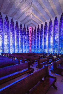 Uzun tahta sandalyeli ve renkli pencereli bir katedralin dikey görüntüsü, Brasil, Sao Paulo