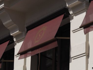 awning of hotel sacher in vienna, red awnings with famous hotel sacher logoin gold on it clipart