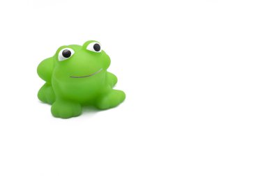Telif alanı beyaz arka planda izole edilmiş yeşil gülümseyen plastik bir kurbağa oyuncağının yakın çekimi