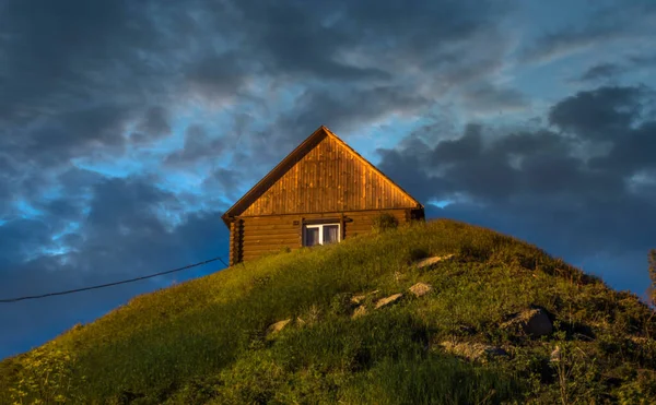 在俄罗斯 在乌云密布的蓝天下 在山顶上的一座木房子的低角拍摄 — 图库照片