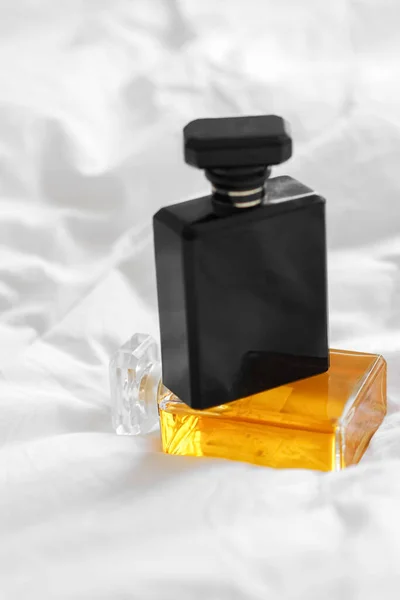 Tiro Vertical Duas Garrafas Perfume Lençol Branco Fundo Embaçado — Fotografia de Stock