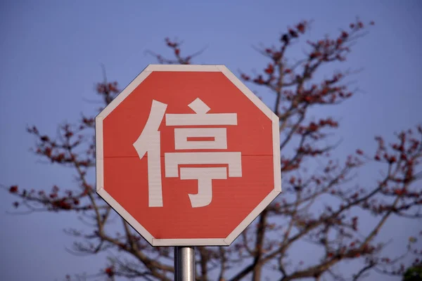 一张特写照片 照片上的白色和红色的中文标志 背景为树木 — 图库照片