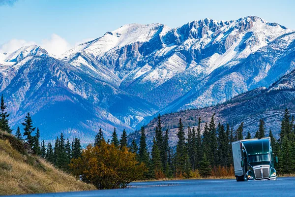 The truck on the road against the beautiful mountain range. Canadian nature.