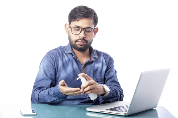 白い背景でコンピュータやラップトップで作業する前に手を消毒する若い男の子 — ストック写真