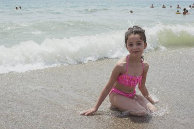 Pembe bikinili kız güneşli bir yaz gününde kumsalda mutlu mesut oynuyor, Vera, İspanya