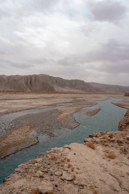 Bulutlu bir günde çöl taşlı dağların dikey görüntüsü.