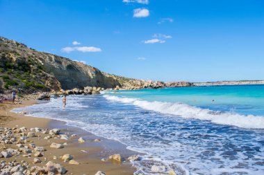 Dalgalar ve mavi Akdeniz Imgiebah Körfezi 'nin kumlu sahilinde, Elmun, Mellieha, Malta yakınlarında, güzel bir sonbahar gününde. Popüler banyo sitesi.