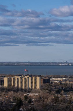 Kanada 'nın Hamilton kentinde Ontario Gölü' nün üzerinde Kanada bayrağı olan dikey bir daire çekimi.