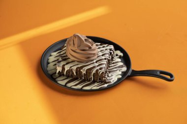 Erimiş siyah beyaz çikolatalı browni ve üstünde dondurma.