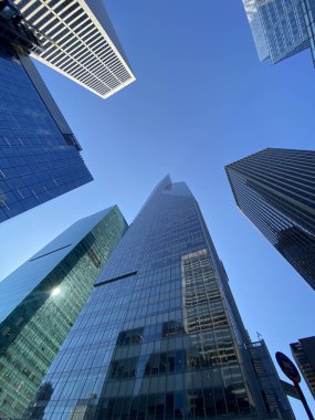 New York, ABD 'de mavi gökyüzü arka planında cam gökdelenlerin dikey görüntüsü