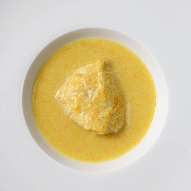 Beyaz tabakta hindistan cevizi sütüyle baharatlı körili tavuğa yakın plan.