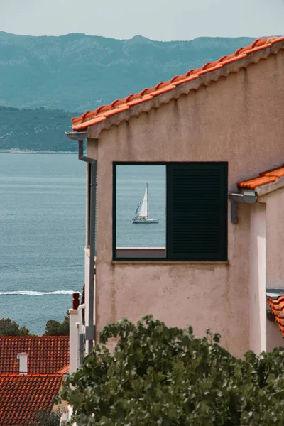 Вертикальный Снимок Судна Плывущего Синему Морю Открытого Окна Прибрежного Дома — стоковое фото