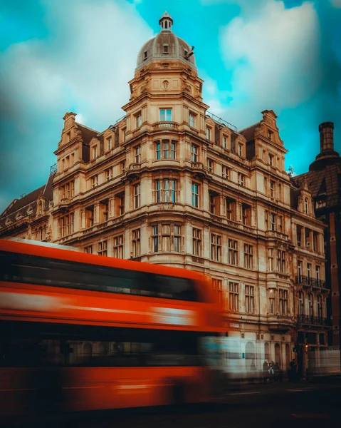 Вертикальный Снимок Автобуса Движении Лондоне Против Исторического Здания — стоковое фото