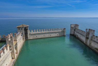 Arkasında gökyüzü olan bir denizin üzerindeki taş bir çitin güzel manzarası.