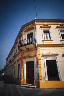 Güzel bir dış tasarım ve mavi berrak gökyüzünün altındaki klasik bir binanın ön görüntüsü.