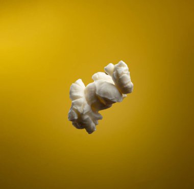 Sarı arka planda izole edilmiş tek bir patlamış mısır.