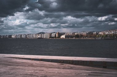 Kasvetli bir günde kıyılarına akan bir nehrin manzarası binalarla kaplıydı.