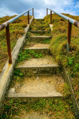 Paslı metal parmaklıkları olan eski bir merdivenin dikey görüntüsü..