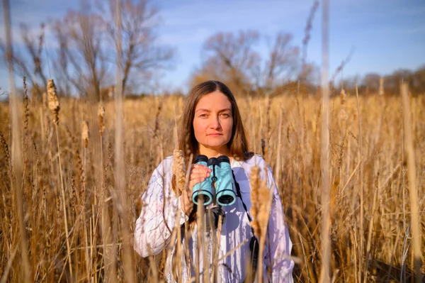 Woman Looking Camera Straight Neutral Expression Blue Binoculars Standing Field — Stock Photo, Image