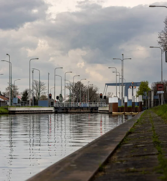 曇った空に対する光柱の反射と川の上の鉄道 — ストック写真