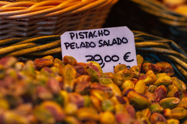 Nut store, bulk pistachio ready for sale, the sign translated into English means salted peeled pistachio, selective approach to the sign.