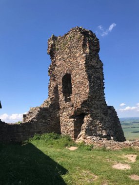 Mavi gökyüzüne karşı Lichnice Kalesi 'nin kalıntılarının dikey görüntüsü.