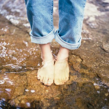 Sudaki kayalıklardaki insan ayağı