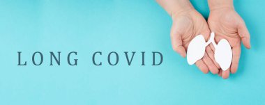 Covid-19 hastalığından sonra uzun cümleler bir kağıdın üzerinde duruyor, eller bir akciğeri tutuyor, solunum problemleri yaşıyor.