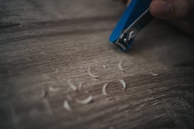 Tırnak makası ve kesilmiş tırnak parçalarının yakın plan çekimi.