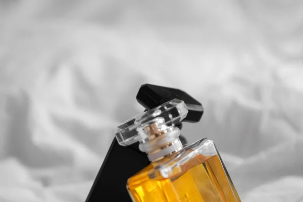 2本の香水瓶のクローズアップは 背景がぼやけている白いベッドシートの上に — ストック写真