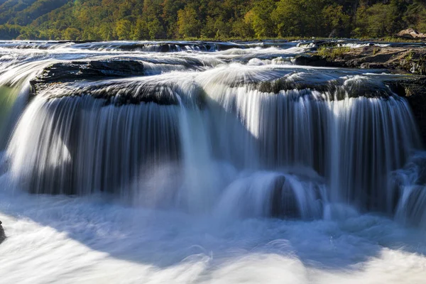 A mesmerizing view of the water stream on rocks of a beautiful waterfall and river