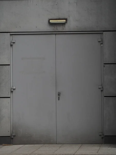 Pionowe Ujęcie Szarości Bez Ycia Metalowe Drzwi Wejściowe Budynku — Zdjęcie stockowe