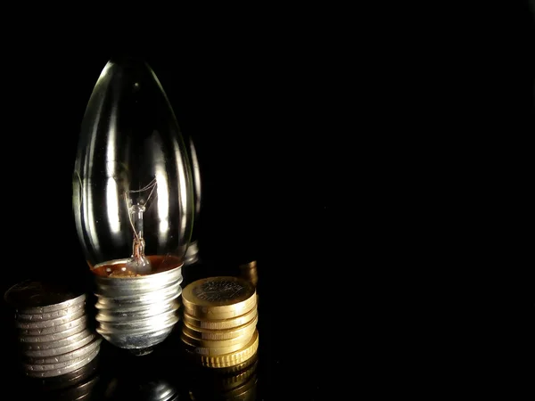 Nahaufnahme Einer Glühbirne Und Münzen Auf Schwarzem Hintergrund — Stockfoto