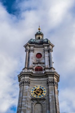 Saint Gallen 'de alçak bir açıdan bulutlu bir gökyüzüne karşı saatli bir kule görüntüsü.