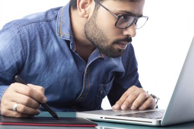 Çizim ve düzenleme için stilus kalem ve dijital tablet kullanan genç dijital sanatçı