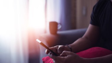 Evde kahve içen ve akıllı telefonunu kullanan yakışıklı İspanyol..