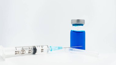 Beyaz arka planda izole edilmiş bir şırınga ve mavi aşı tüpü.