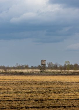 Arka planda tarım arazileri ve av kulesi olan güzel bir manzara.