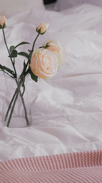 Pionowe Ujęcie Róż Ogrodowych Szklanym Wazonie Białej Pogniecionej Pościeli — Zdjęcie stockowe