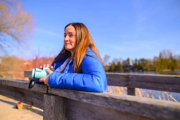 Woman Blue Jacket Looks Distance Bridge Holding Binoculars Park Sunny — Stock Photo, Image