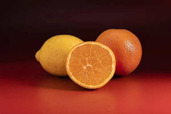 Ένα Κοντινό Πλάνο Πορτοκάλια Και Ένα Λεμόνι Μια Κόκκινη Επιφάνεια — Φωτογραφία Αρχείου