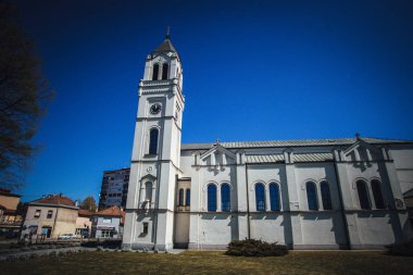 Brcko 'daki ön bahçeli ve ağaçlı katolik kilisenin dış tasarımı çok güzel.