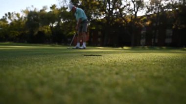 Yeşil çimlerde golf oynayan bir erkek.