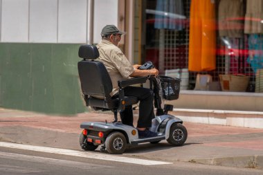 Ronda, Malaga, İspanya 20 Haziran 2022 Elektrikli araçla caddeyi geçen adam.