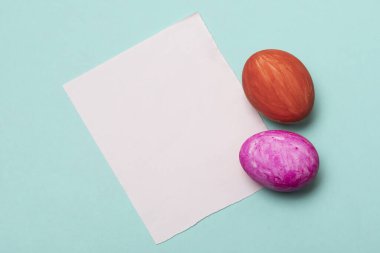 Beyaz kağıtlı Paskalya yumurtalarının yakın plan resmi. Açık mavi arkaplan ve fotokopi alanı.